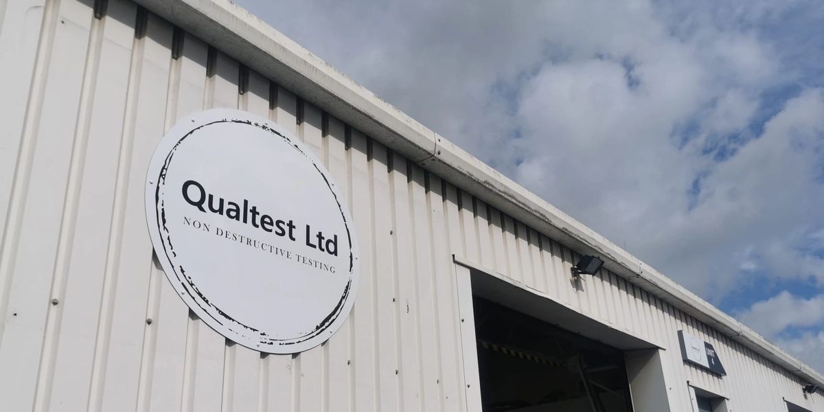 The Qualtest unit, a light industrial building with the company stamp painted on the wall