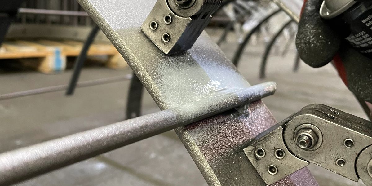 A magnetic particle yoke straddling a welded joint on a fabricated part